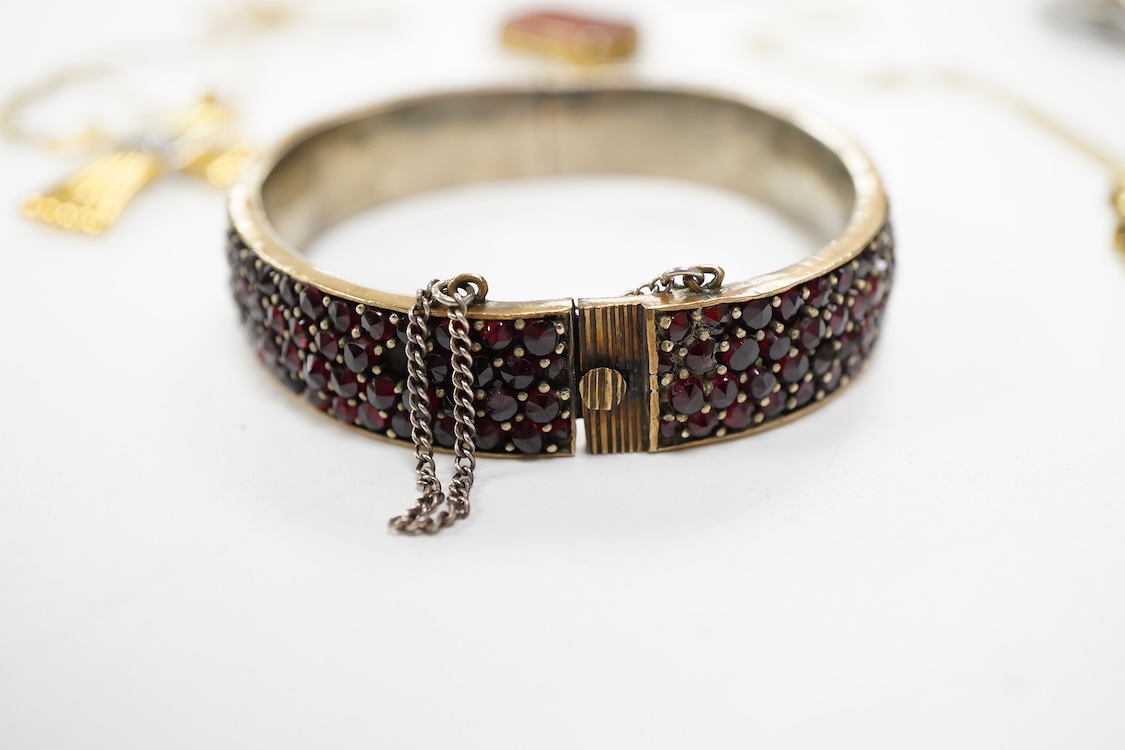 An 800 standard gilt white metal and garnet cluster set oval pendant, 18mm, on a 585 yellow metal fine link chain, 2.5 grams, a gilt white metal and garnet cluster set hinged bangle, two white metal brooches including on